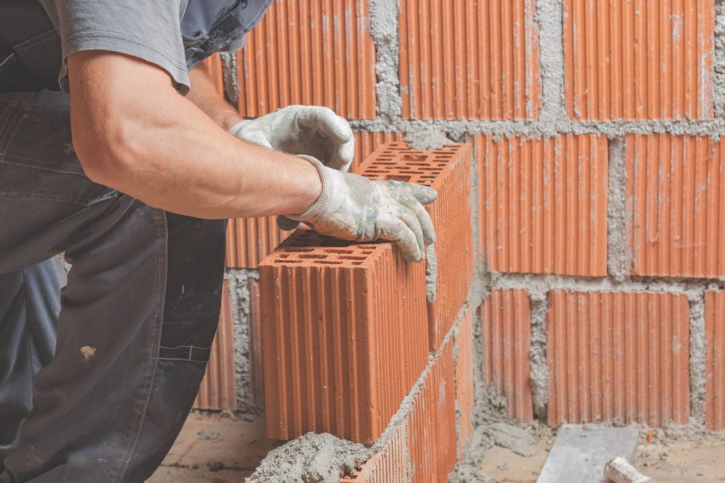 bricklayer stacking wall of bricks cardiff