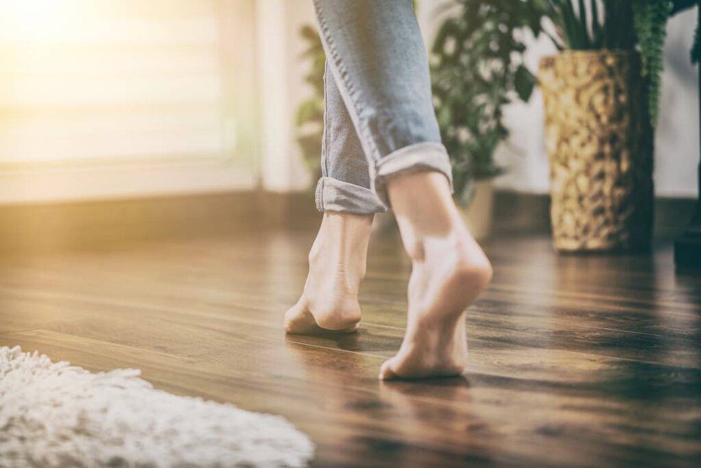 Underfloor Heating Woman Walking On Wooden Floor With Underfloor Heating